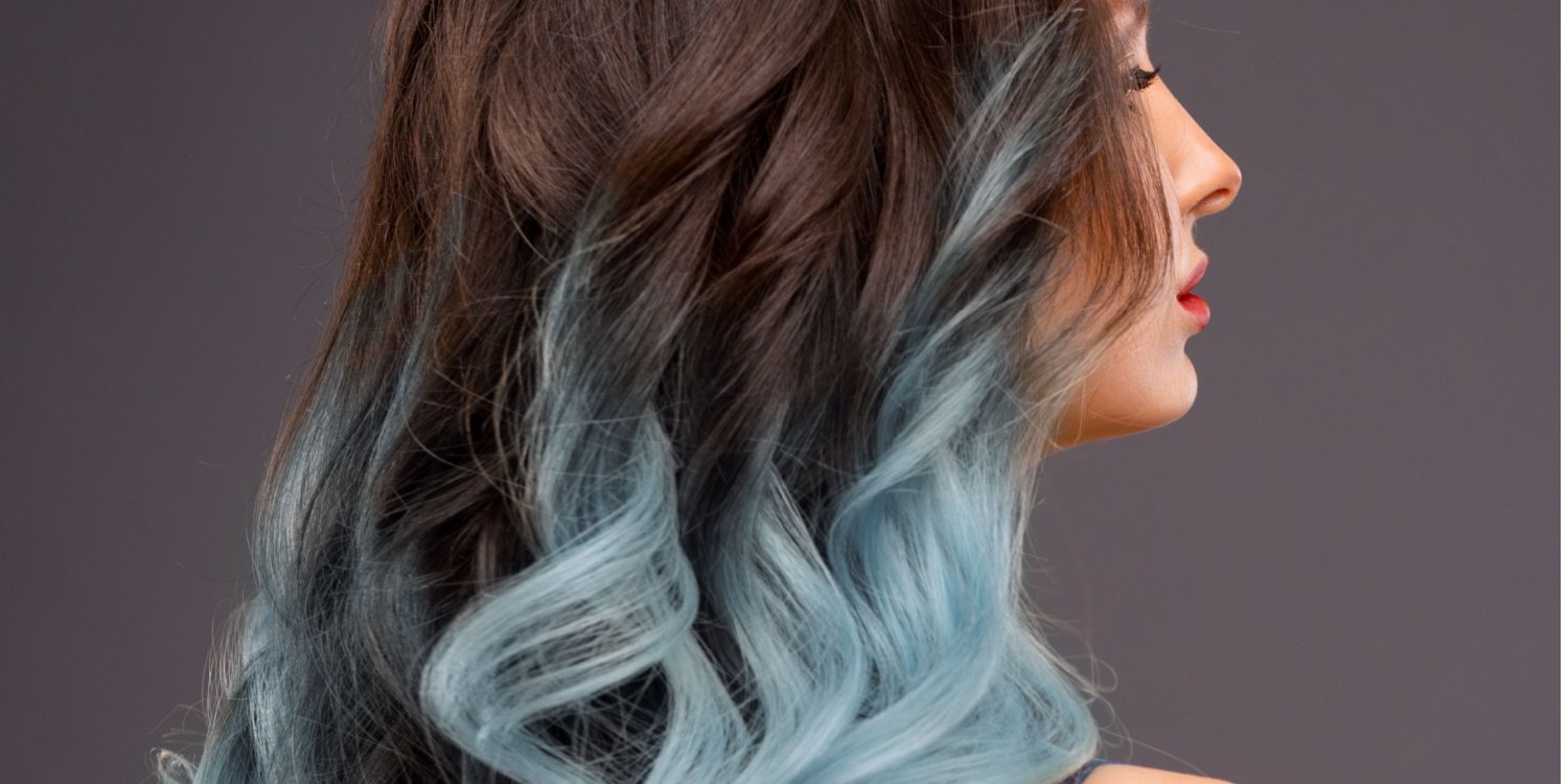 Back view of long, wavy hair with a gradient from dark brown to pastel blue.